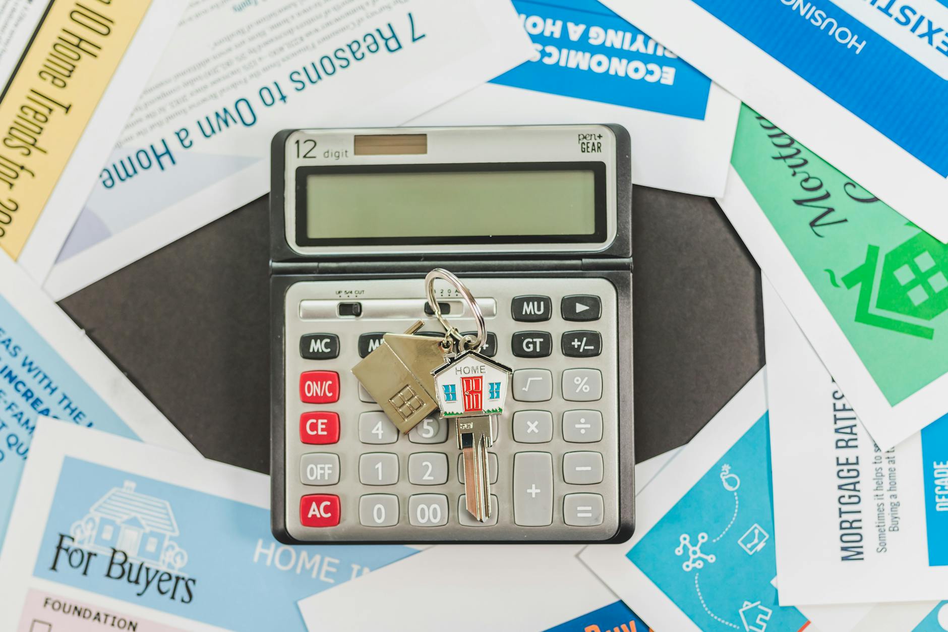 Calculator surrounded by real estate documents, symbolizing home buying finances and planning.