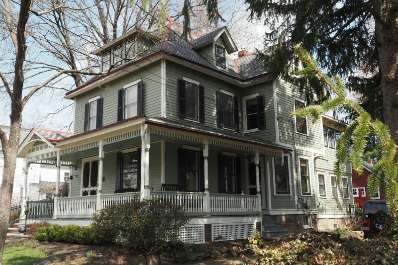 Victorian house surrounded by lush trees in springtime, located in Newtown, Pennsylvania.