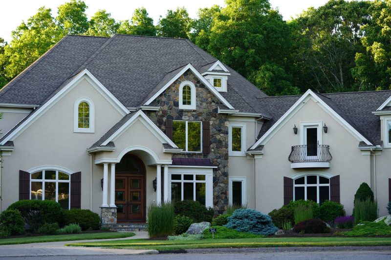 Large suburban house with a charming facade, surrounded by vibrant greenery and well-maintained landscaping.