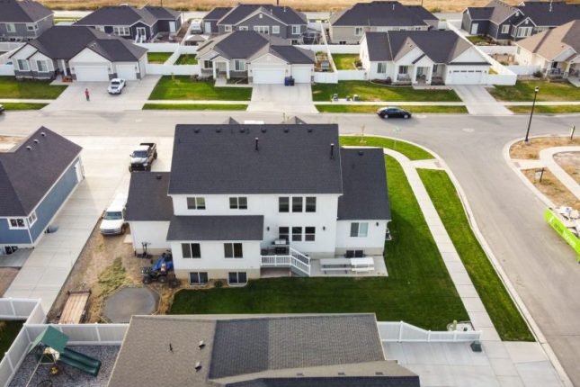 Aerial view of modern homes with green lawns in a residential area of Spanish Fork, Utah.