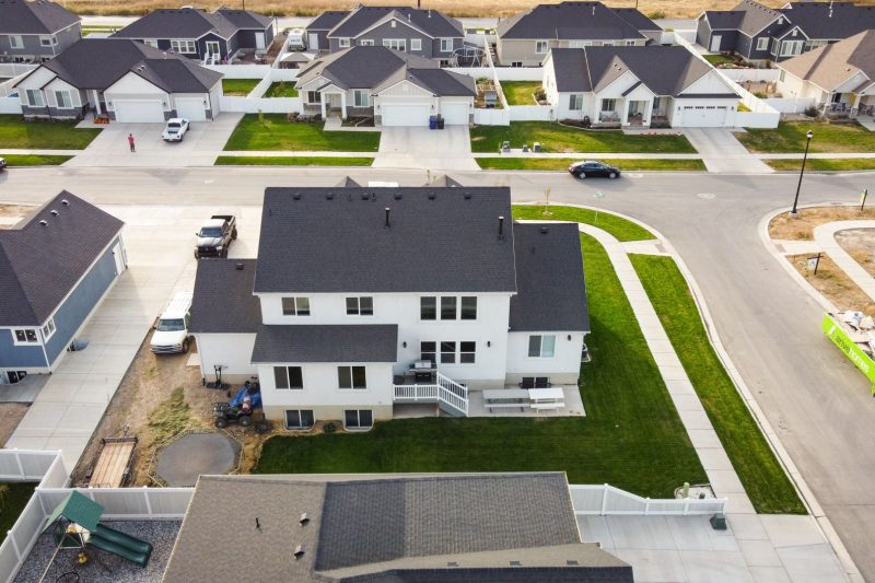 Aerial view of modern homes with green lawns in a residential area of Spanish Fork, Utah.