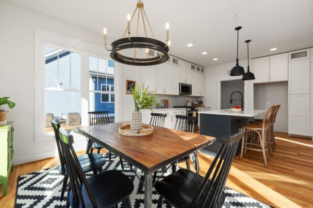 Bright and modern kitchen and dining area featuring stylish furnishings and abundant natural light.